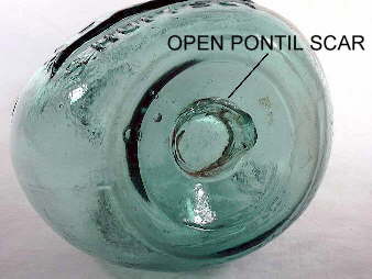 Glass-tipped "blow-pipe" or "open" pontil scar on base of a bottle.  Click to view a larger version of picture.