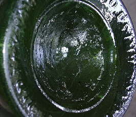 Sand pontil scar on the base of an 1822 English liquor bottle; click to enlarge.